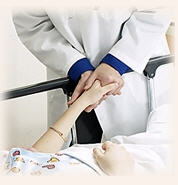 Doctor holding the hand of a patient in a hospital bed